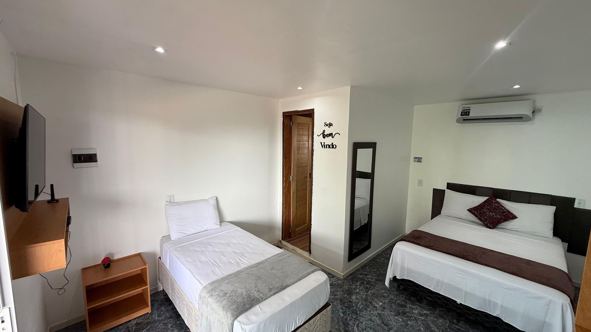 Um quarto de hotel com duas camas e uma televisão.