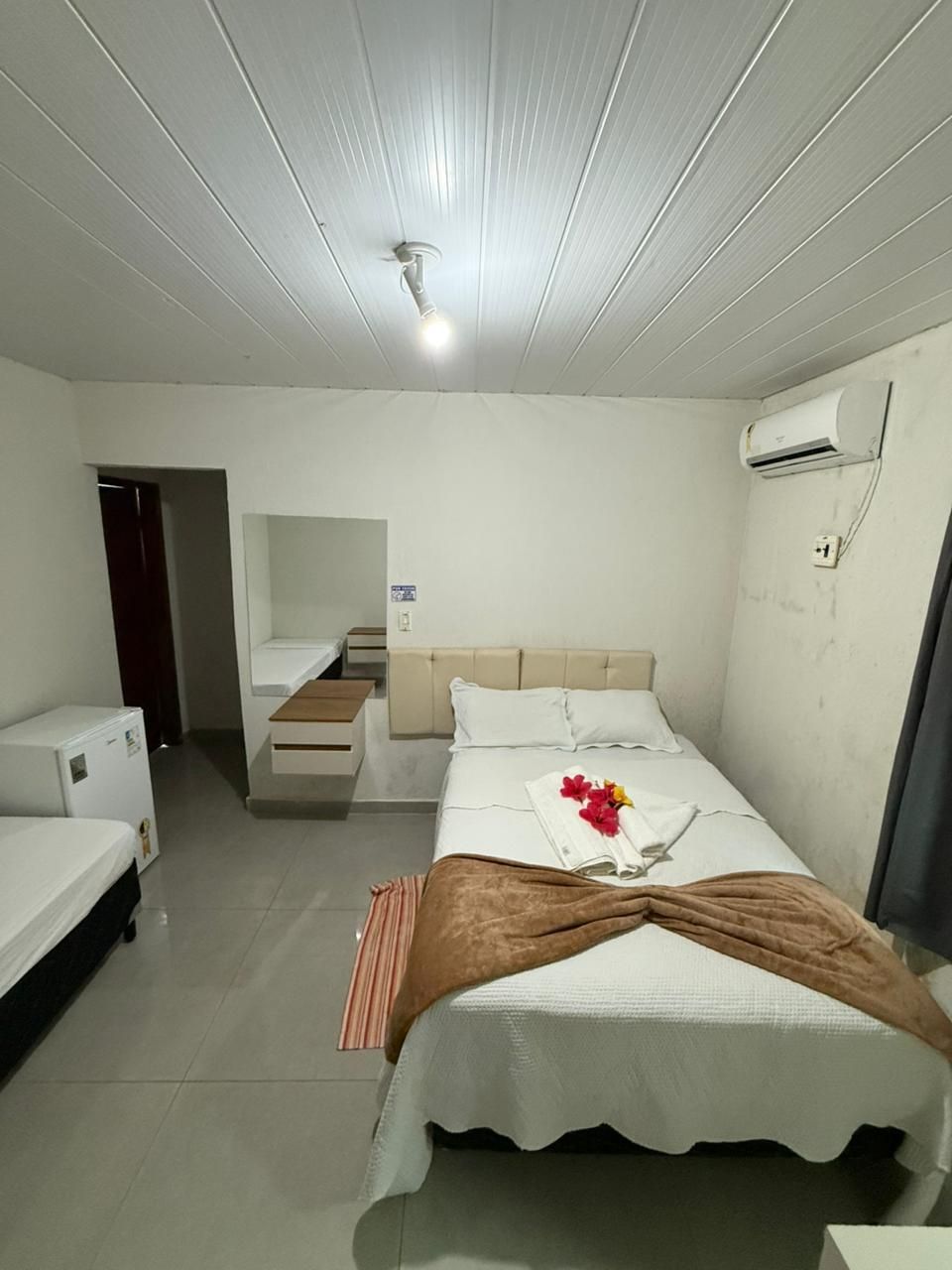 Há uma cama grande no meio do quarto.