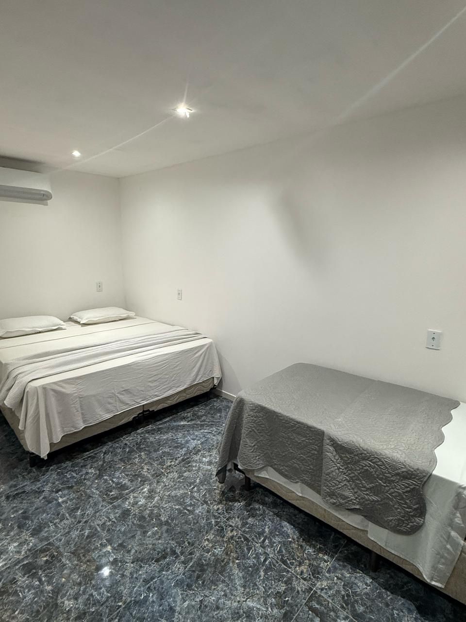 Um quarto com duas camas e uma cama de solteiro.