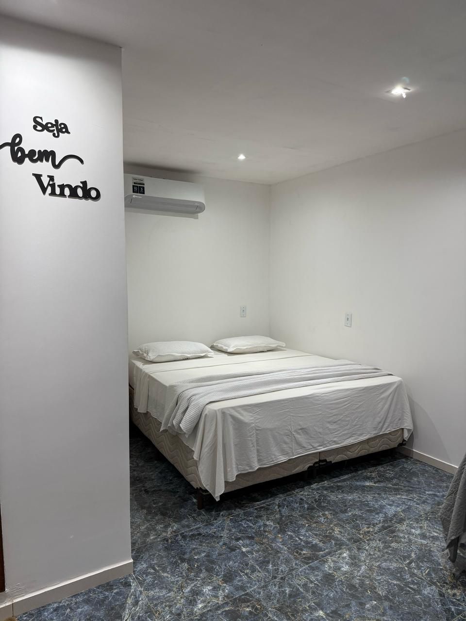 Um quarto com uma cama grande e uma placa na parede.