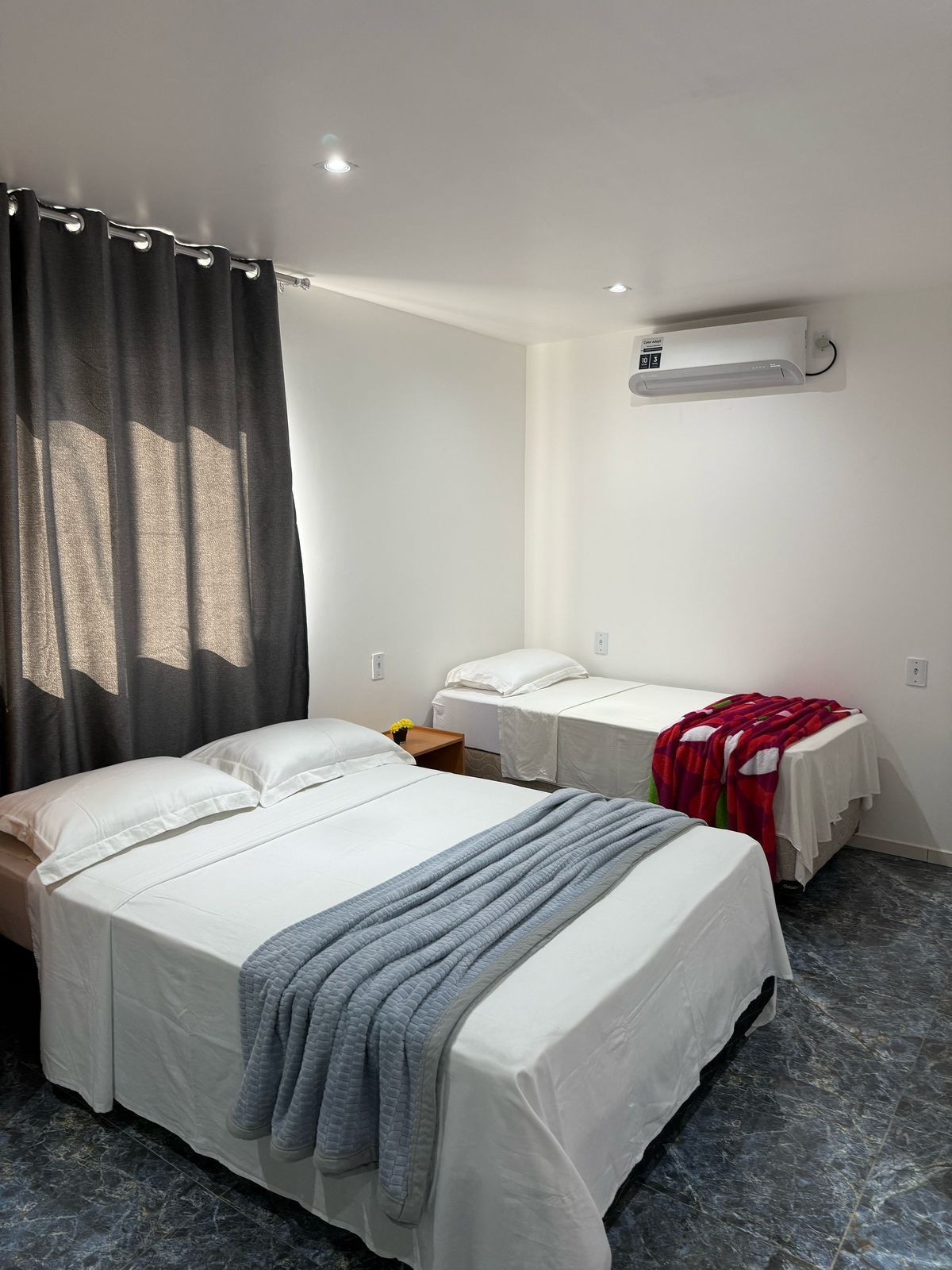 Um quarto de hotel com duas camas e uma janela.