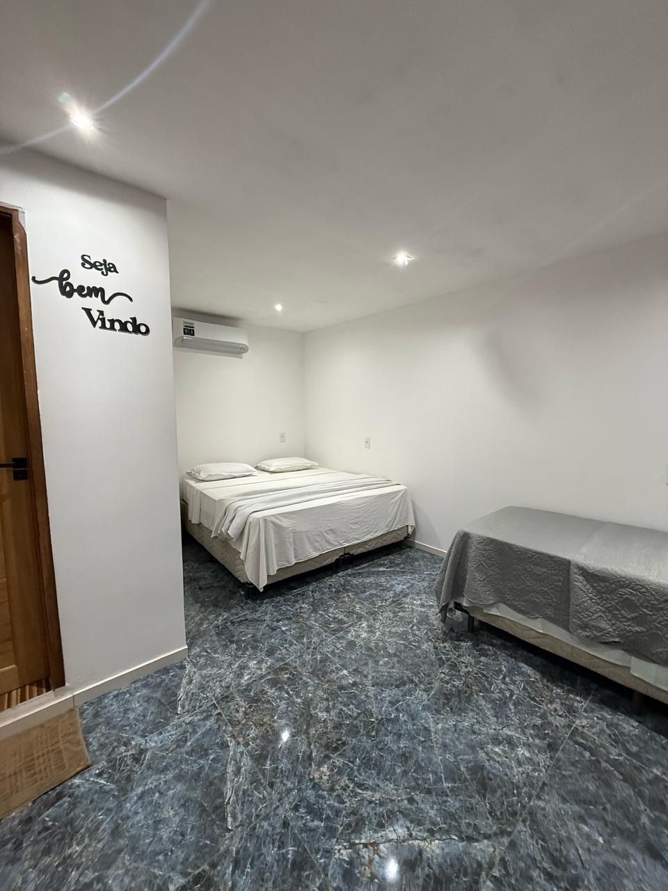 Há uma cama grande no meio do quarto.