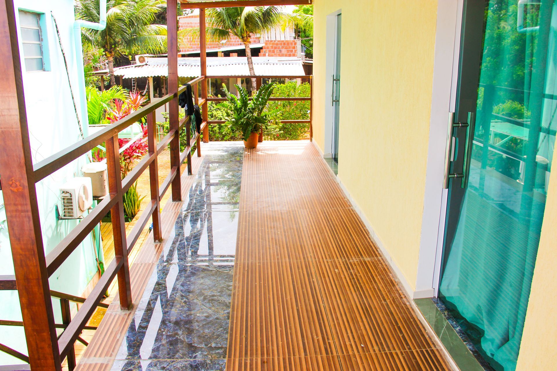 Um corredor com piso de madeira e uma porta de vidro