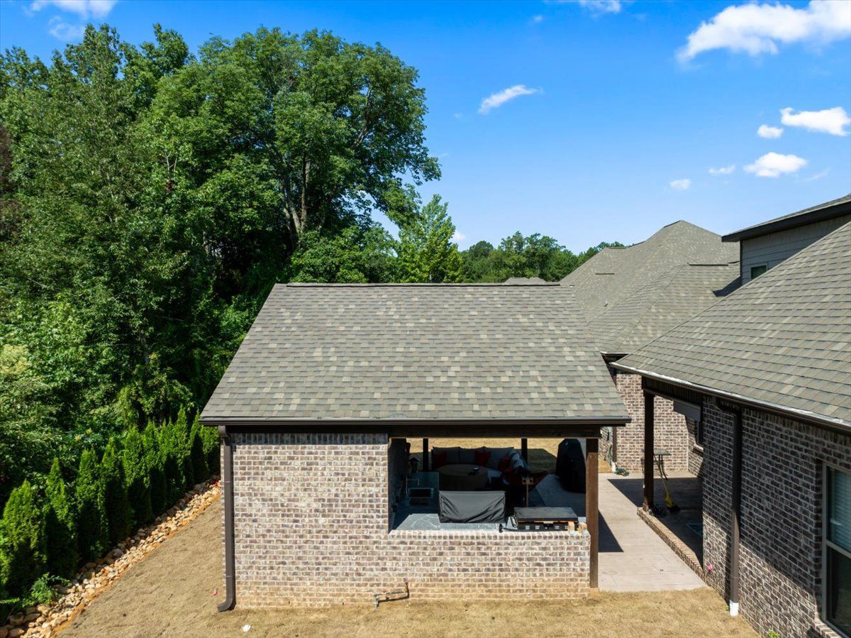 An aerial view of a brick house with a covered patio.