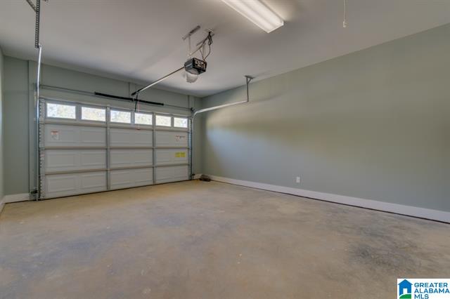 an empty garage with a garage door open and a light on the ceiling .