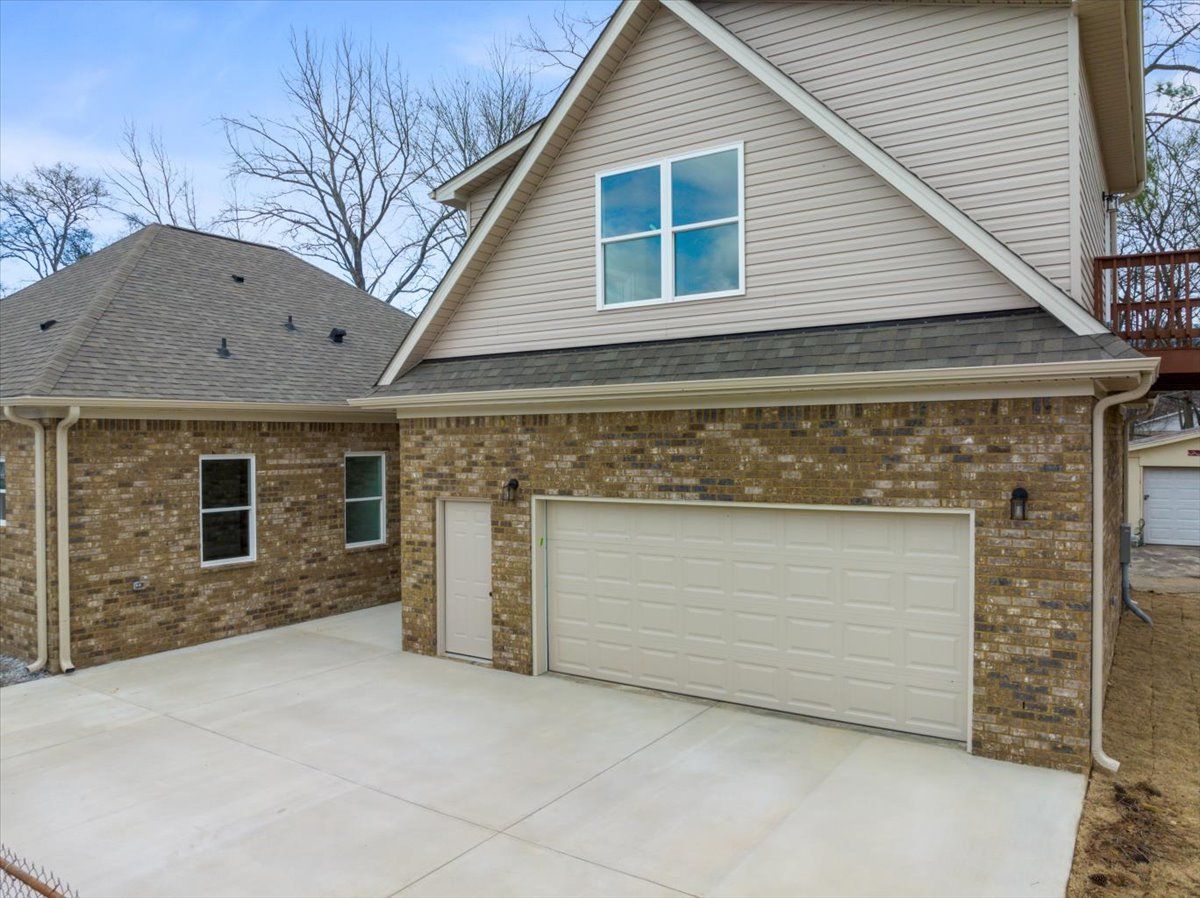 a large brick house with a garage and a balcony .