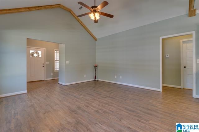 a living room with a vaulted ceiling and a ceiling fan