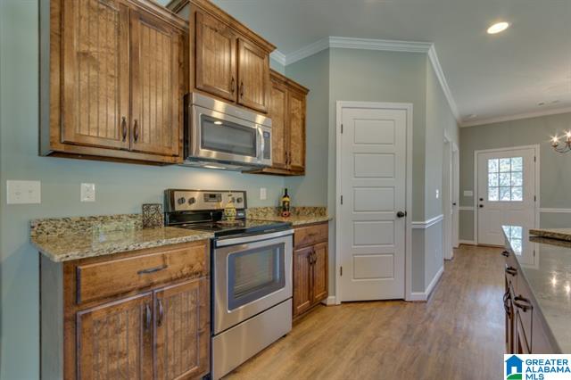 a kitchen with wooden cabinets , stainless steel appliances , and granite counter tops .
