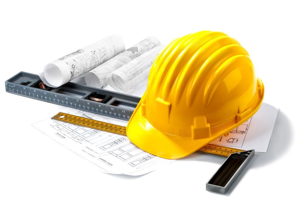 a yellow hard hat is sitting on top of a ruler and blueprints .