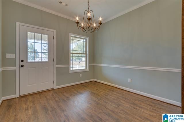 an empty room with a chandelier and a window