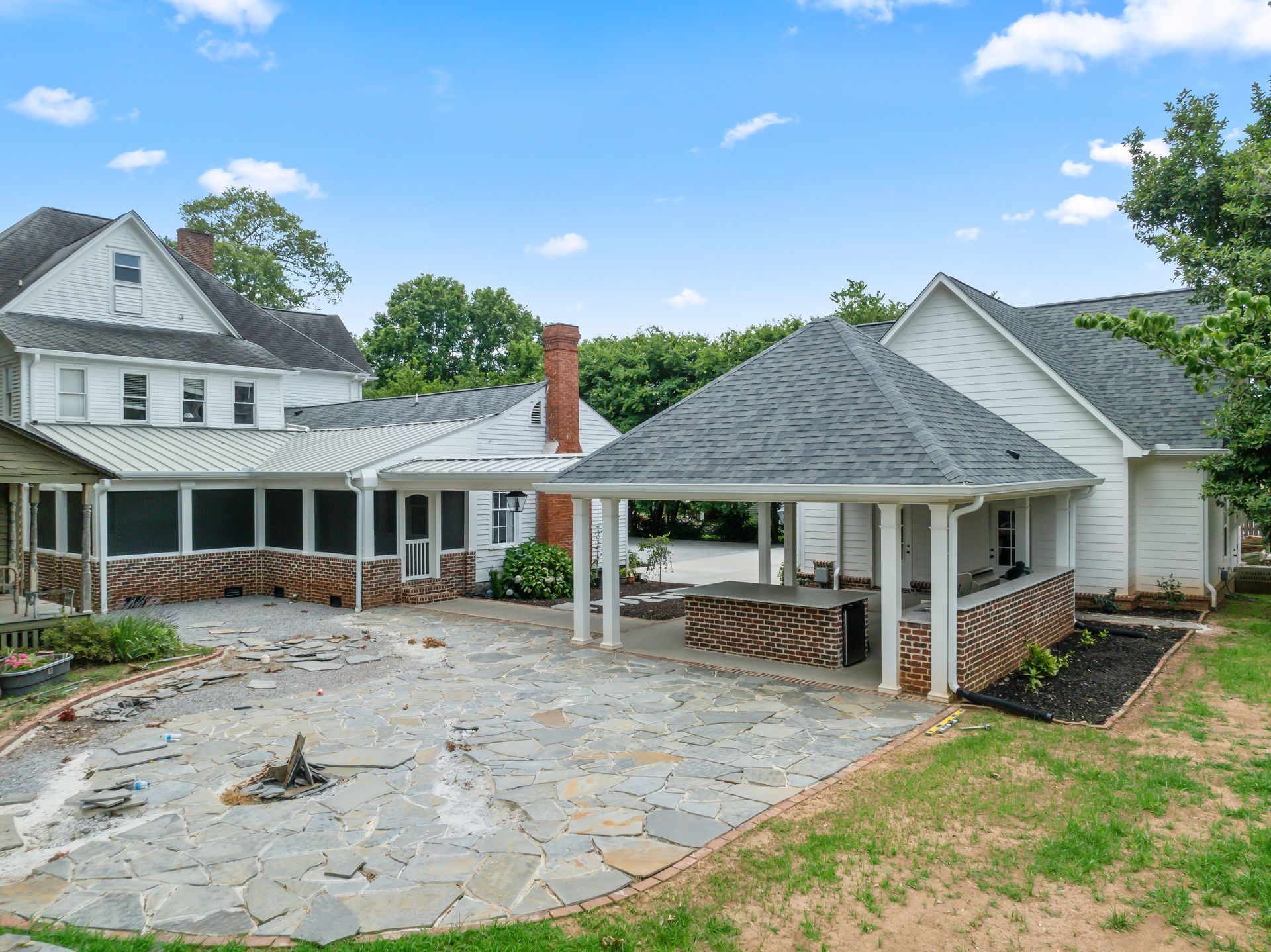 A large white house with a covered patio in front of it.