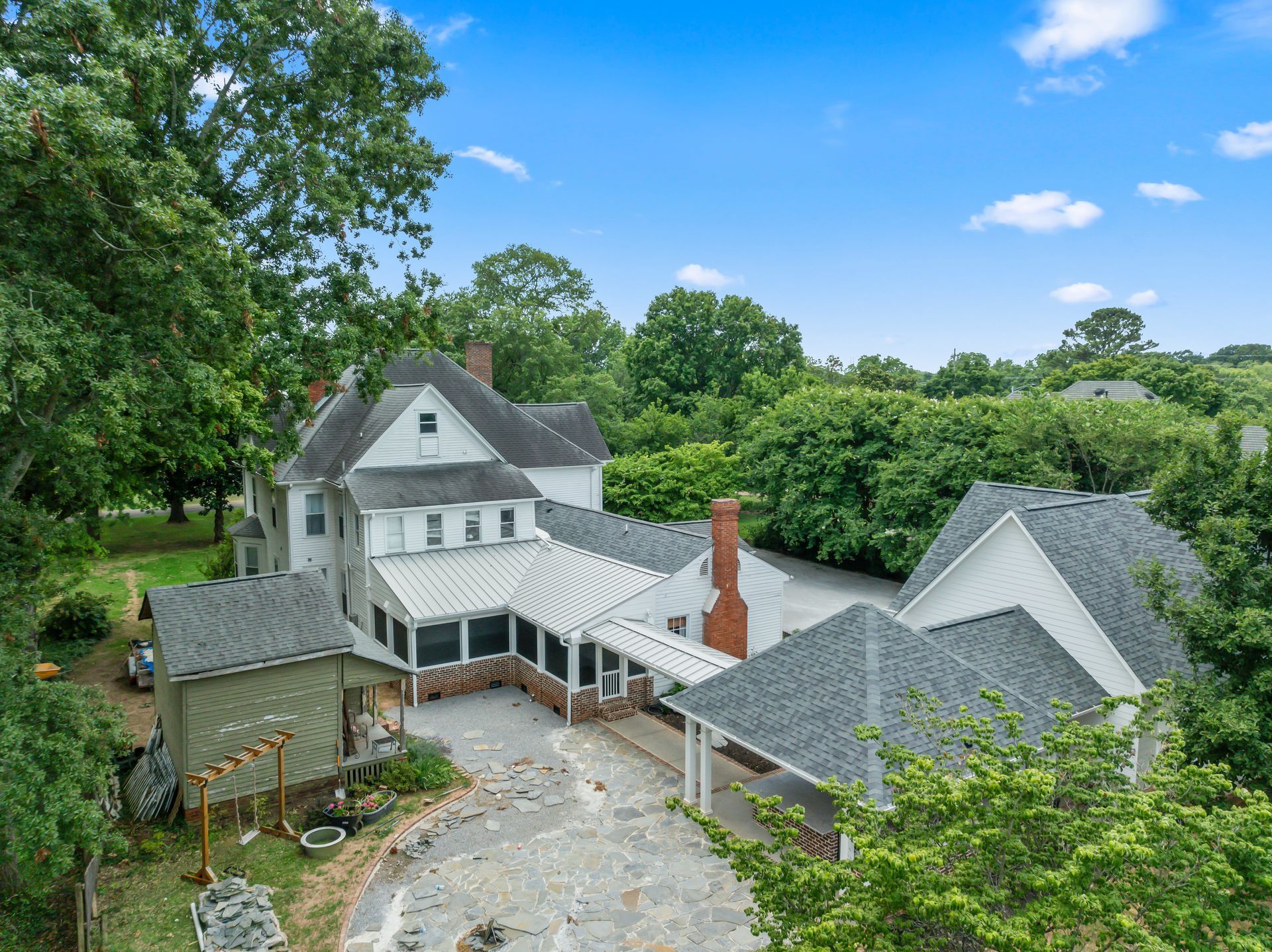 An aerial view of a large white house surrounded by trees.