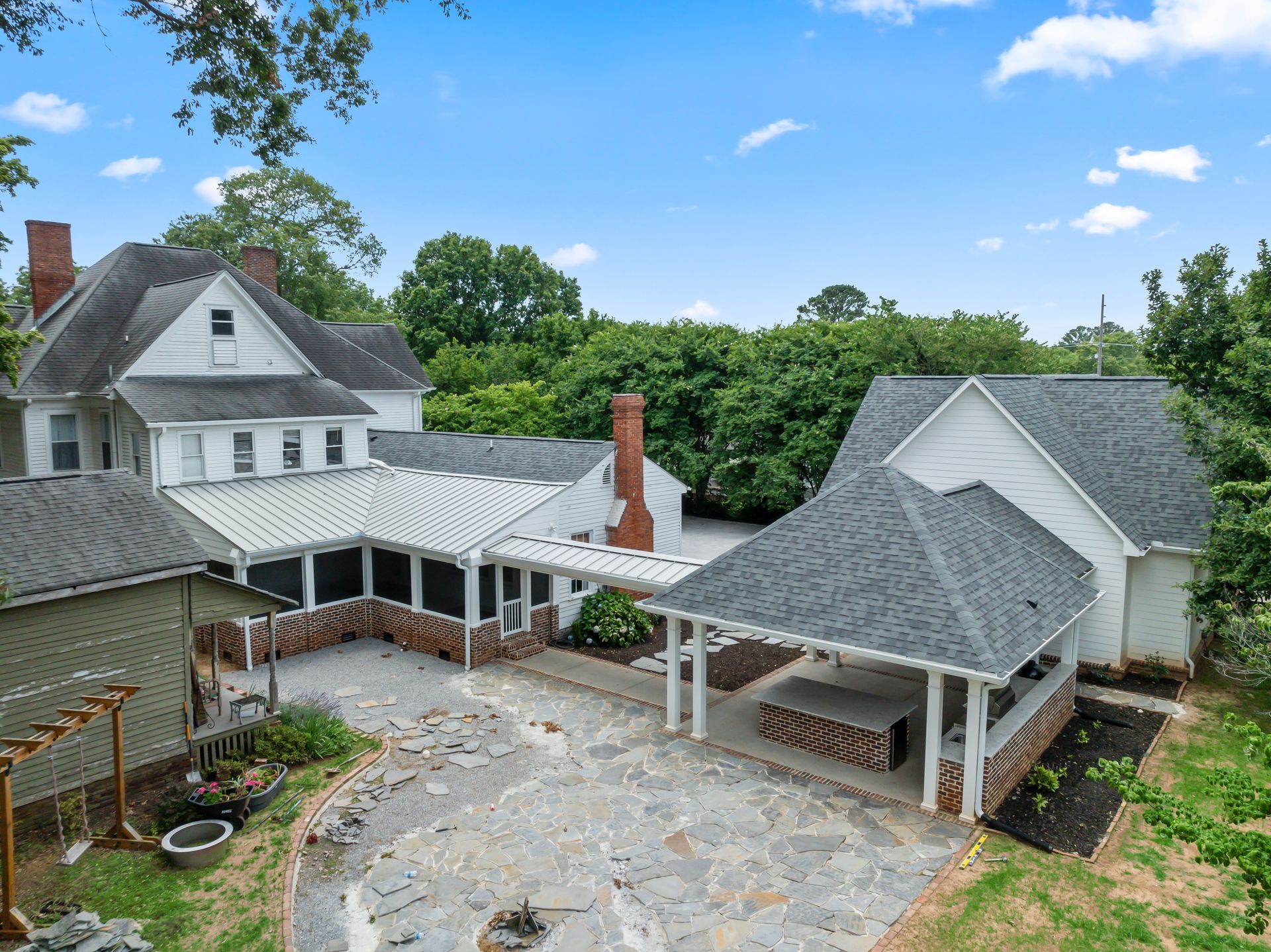 An aerial view of a large white house with a gray roof.