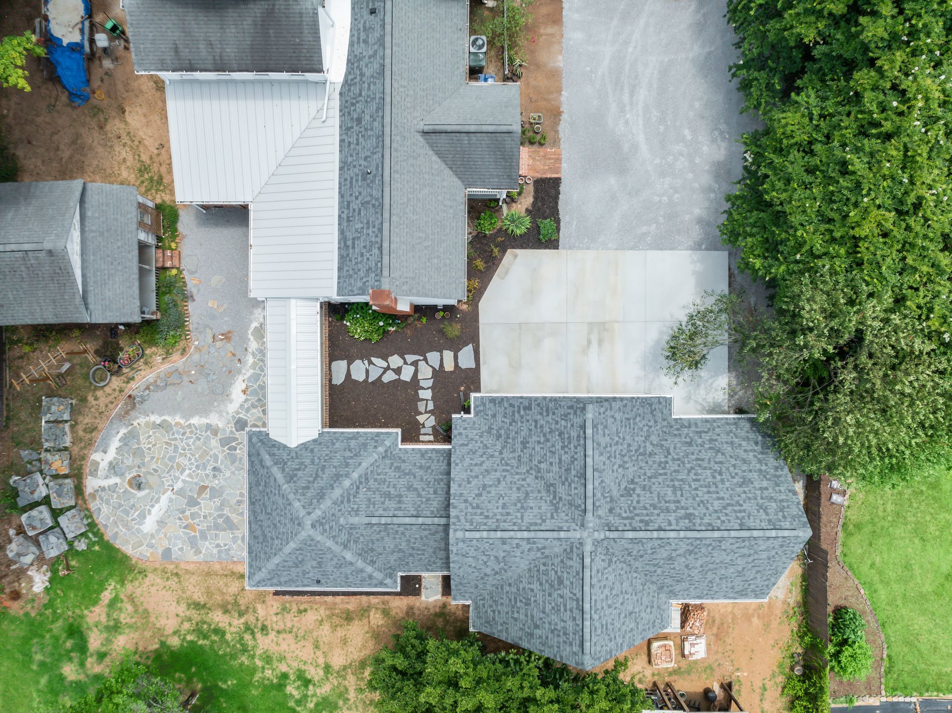 An aerial view of a house with a gray roof and a driveway.