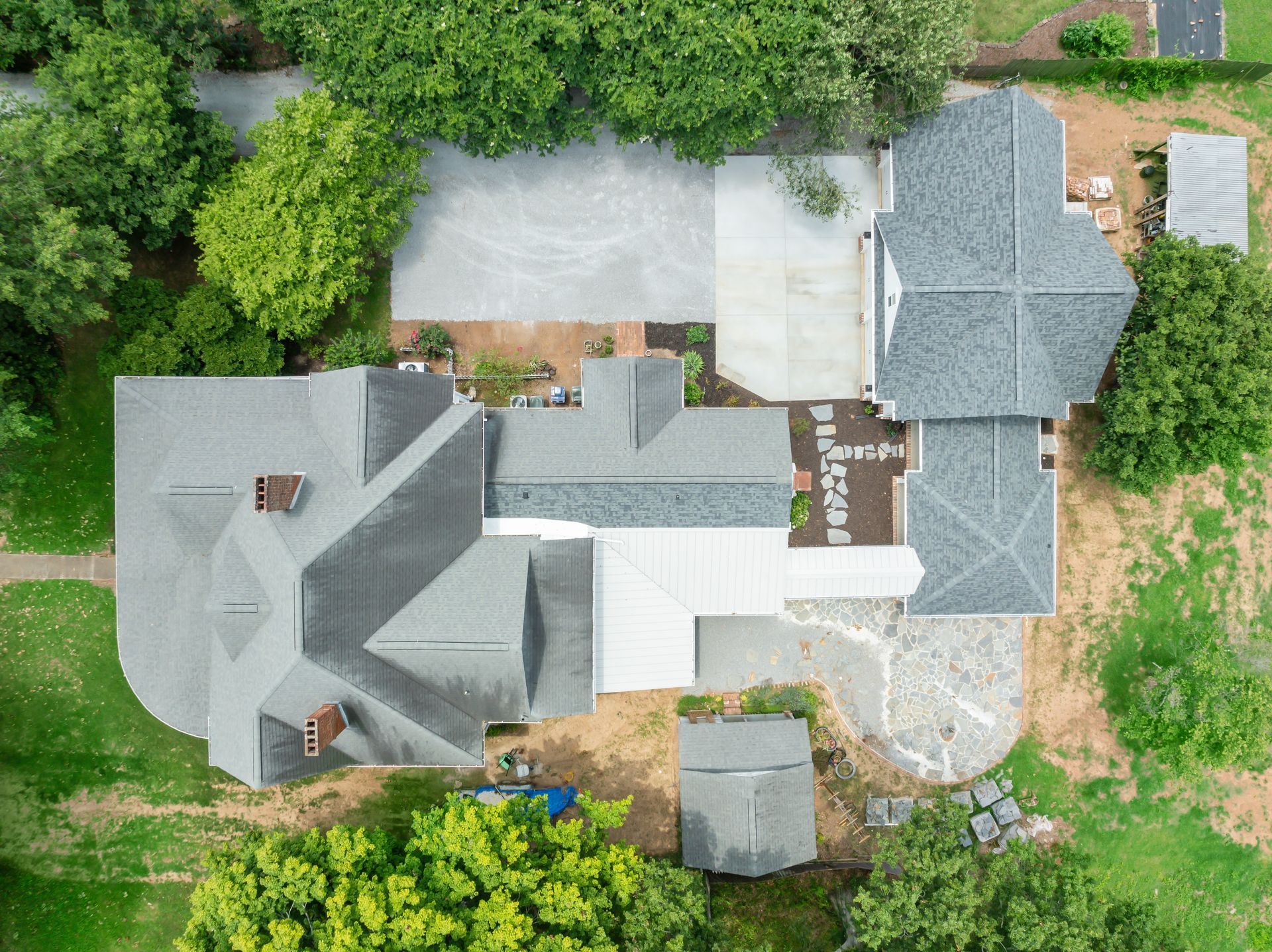 An aerial view of a large house surrounded by trees and grass.