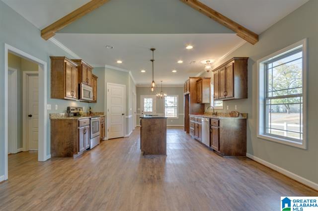 a kitchen with wooden cabinets , stainless steel appliances , and a large island .
