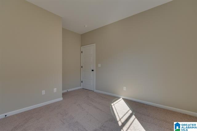an empty bedroom with a white door and tan walls