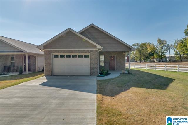 a house with a garage and a fence in front of it .