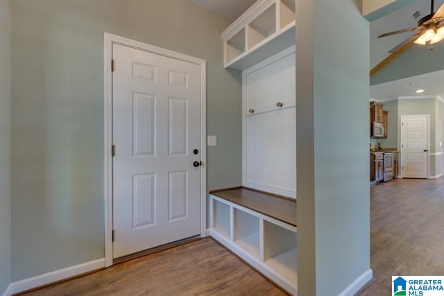 a hallway in a house with a white door and a bench