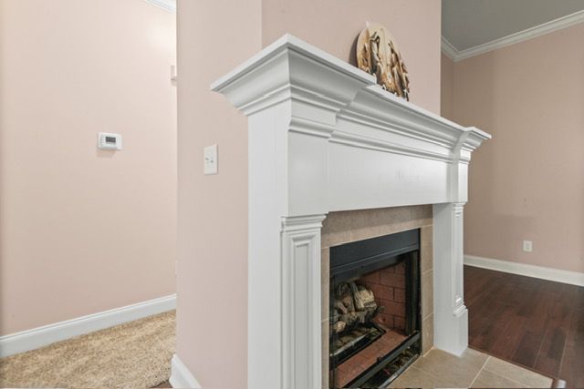 A fireplace with a white mantle in a living room. By Mims custom home construction