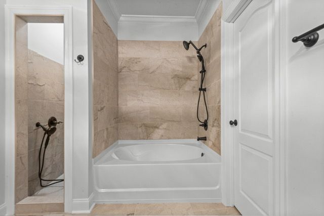 A bathroom with a tub and a shower. By Mims custom home construction
