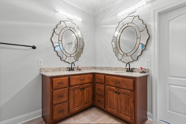 A bathroom with two sinks and two mirrors. By Mims custom home construction