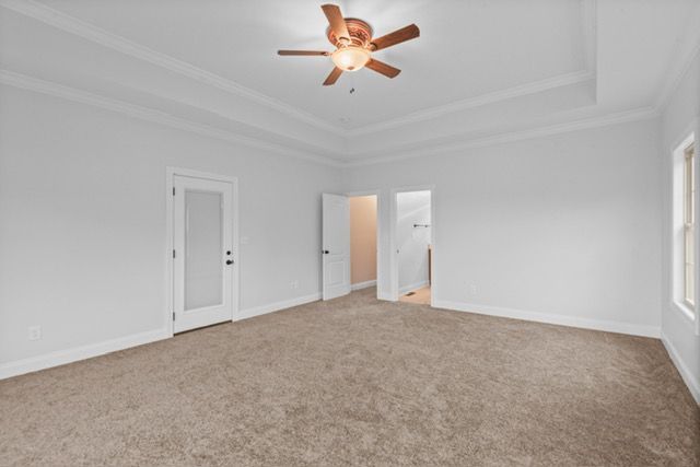 An empty bedroom with a ceiling fan and a window. By Mims custom home construction