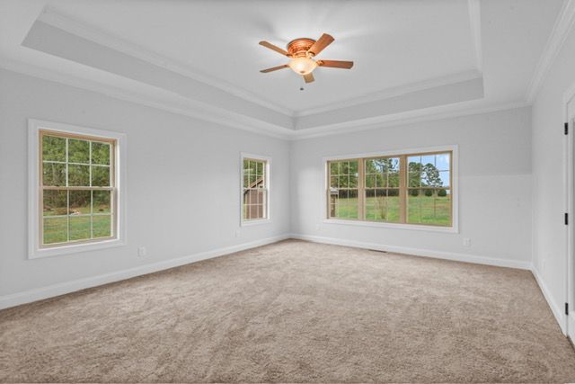 An empty bedroom with a ceiling fan and three windows. By Mims custom home construction