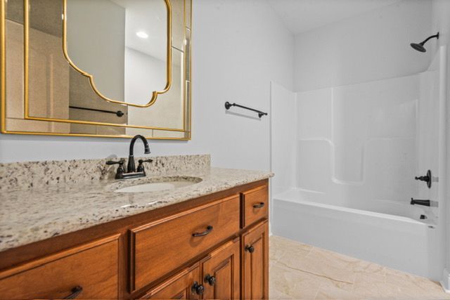 A bathroom with a sink , mirror and bathtub. By Mims custom home construction