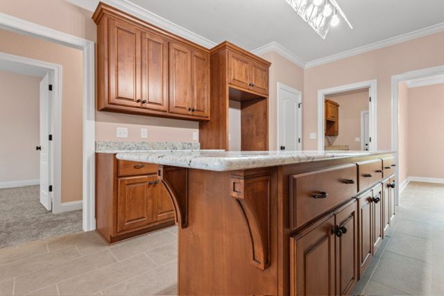 There is a large island in the middle of the kitchen. By Mims custom home construction