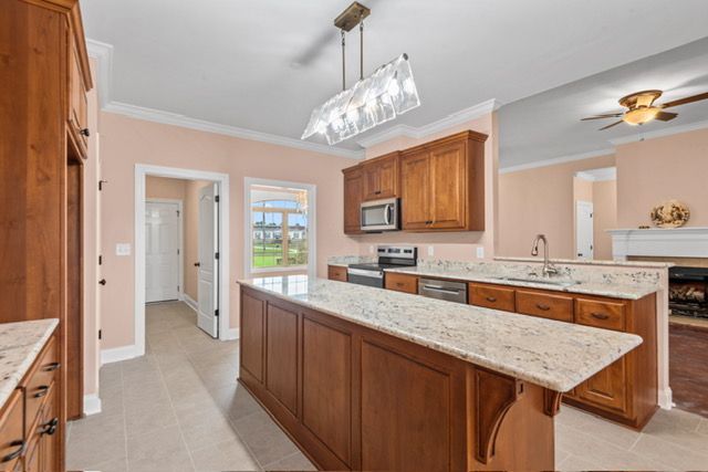 A kitchen with wooden cabinets and granite counter tops. By Mims custom home construction