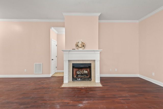 An empty living room with a fireplace and pink walls. By Mims custom home construction