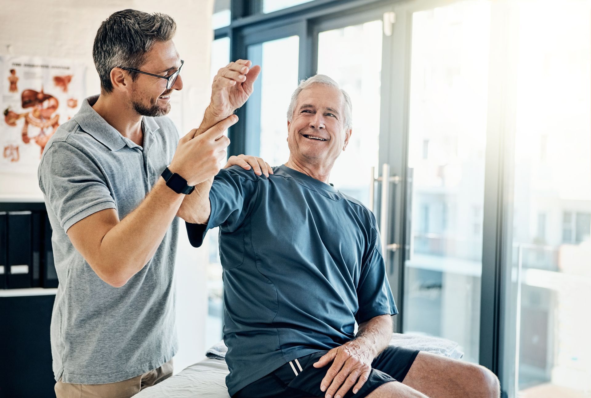 Physical therapist assisting an older adult with shoulder stretch exercise indoors. Physical therapist assisting an older adult with shoulder stretch exercise indoors.
