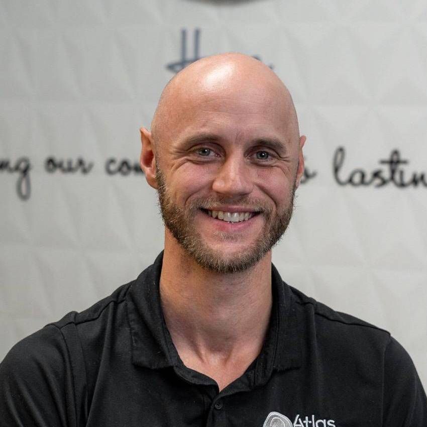 Bald man with a beard smiles, wearing a black shirt. White background with script. Bald man with a beard smiles, wearing a black shirt. White background with script.