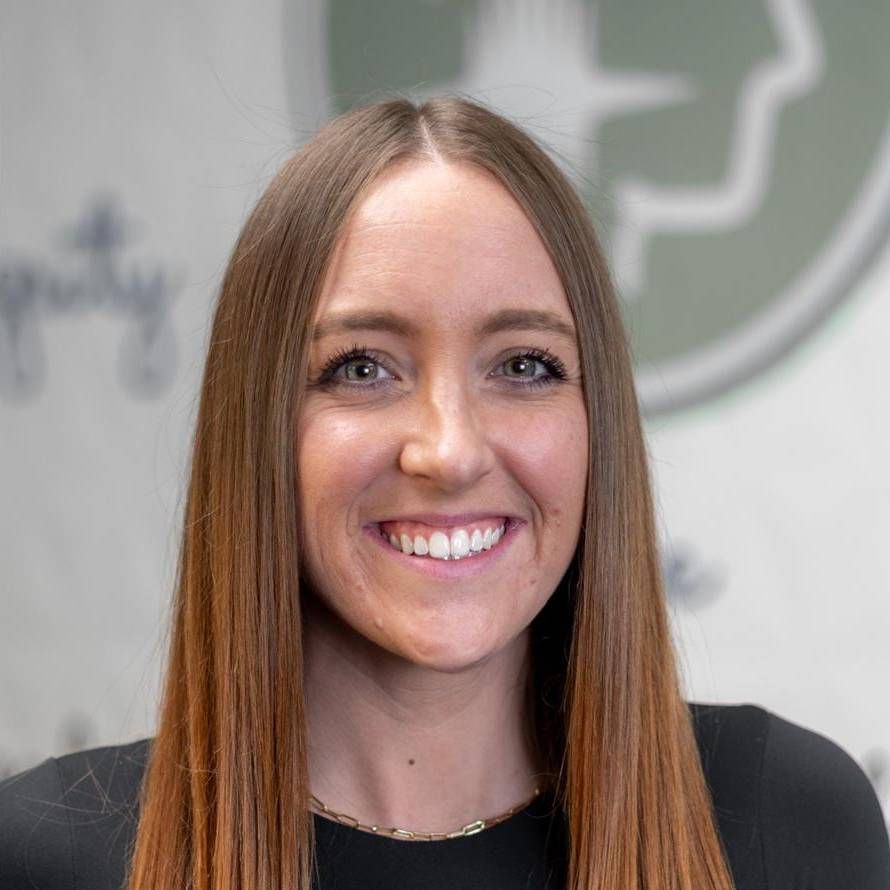 Woman with long brown hair smiling at the camera, wearing a black shirt and gold necklace. Woman with long brown hair smiling at the camera, wearing a black shirt and gold necklace.