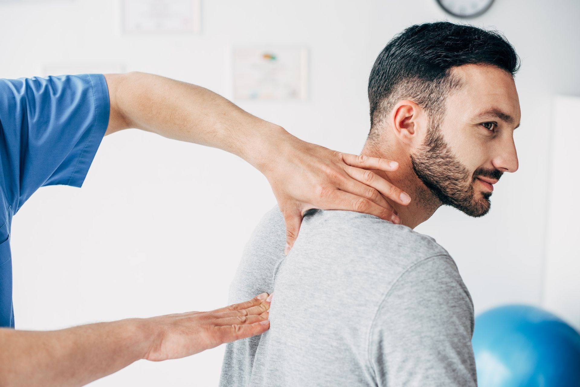 Man receiving neck and back examination in a clinical setting.
