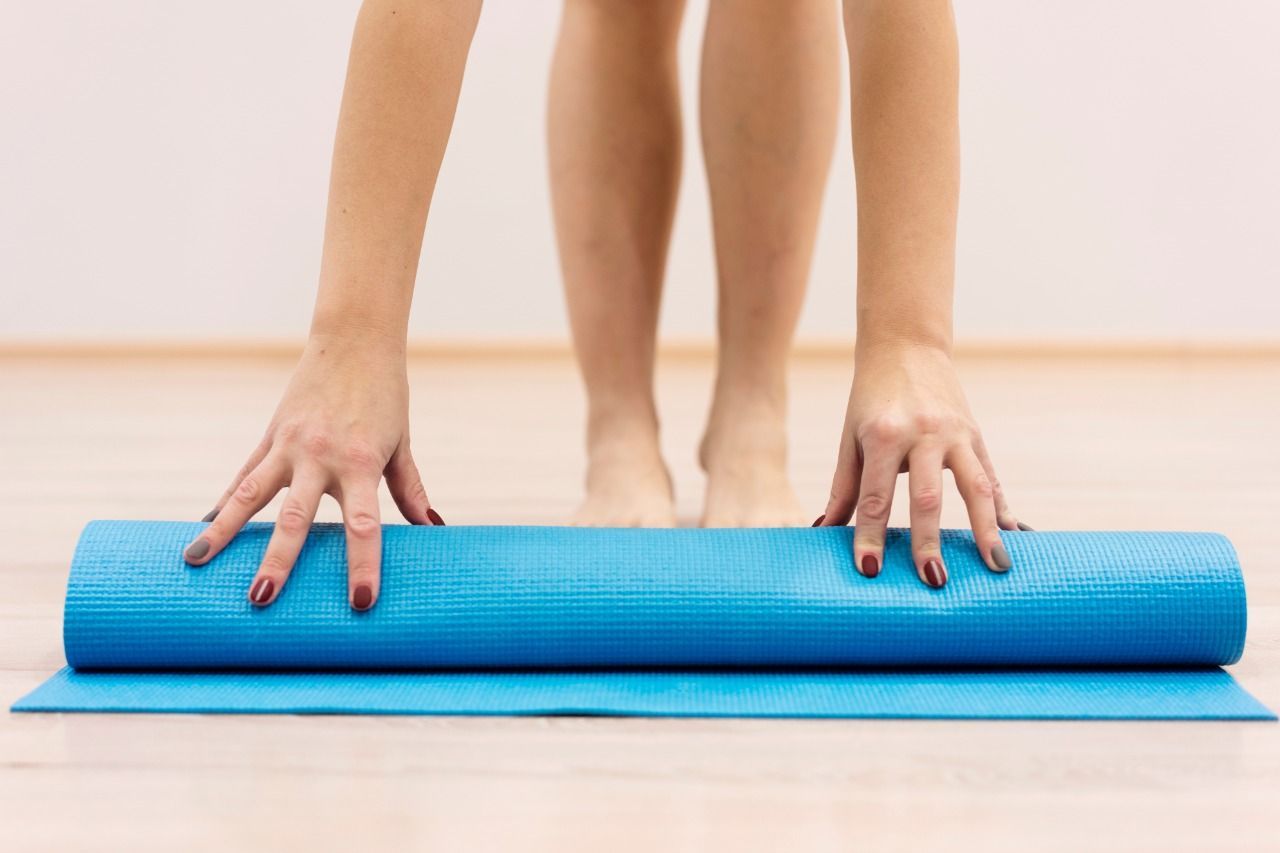 uma mulher está de pé sobre um tapete de ioga azul.