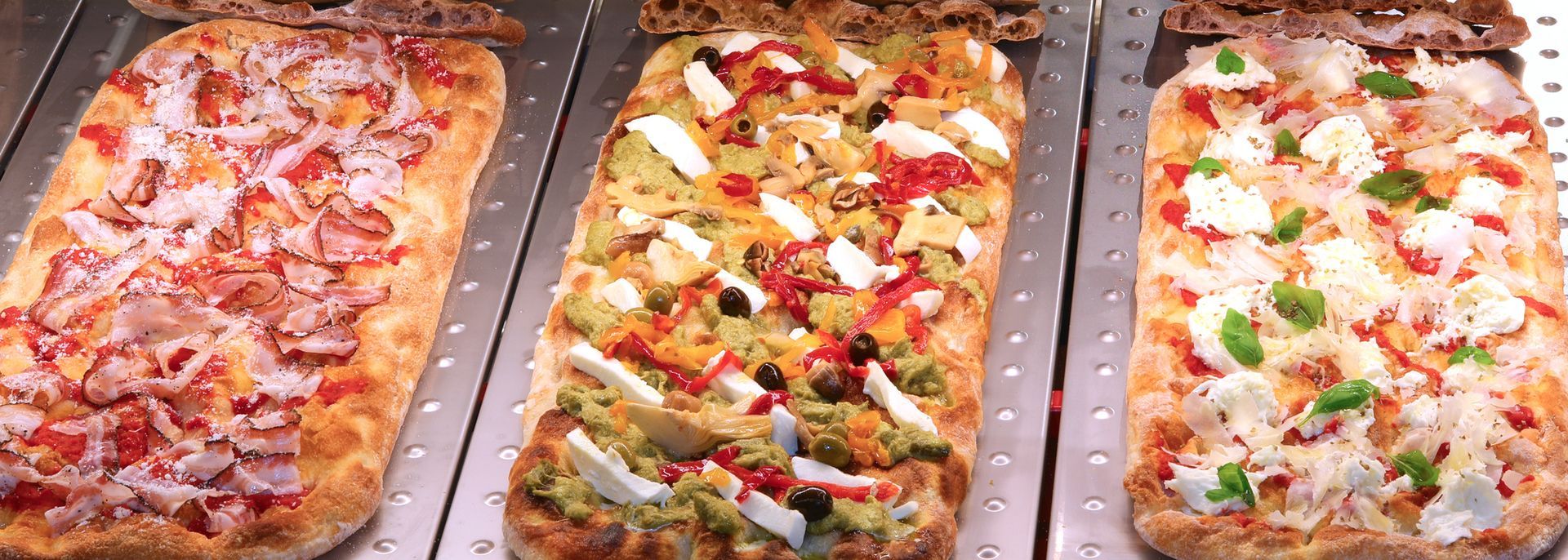 Un bicchiere di vino rosso, un tagliere di salumi con carne e pane e un cocktail in un ristorante.