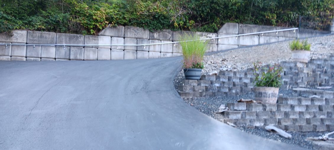 A road with a stone wall on the side of it.
