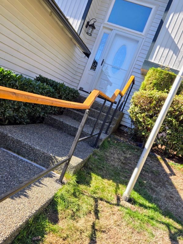 A set of stairs leading up to a house with a wooden railing.