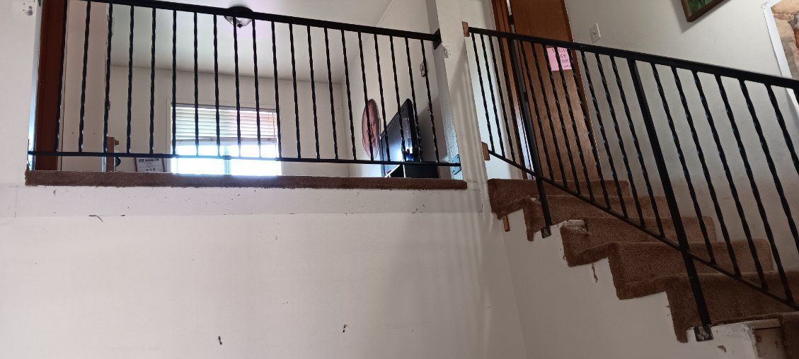 A staircase with a wrought iron railing in a house.