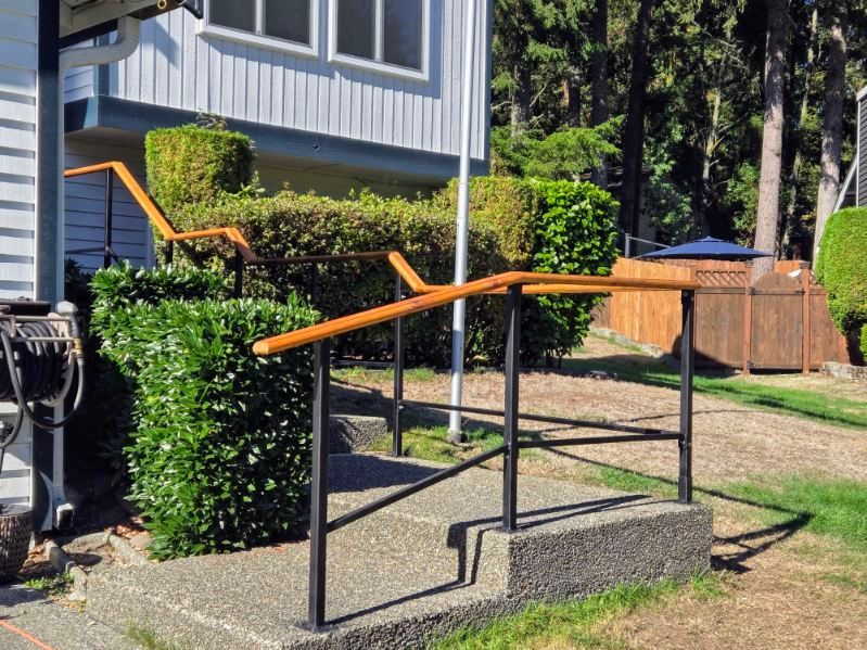 A staircase with a railing leading up to a house.