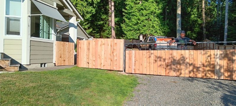 A wooden fence is being built in front of a house.