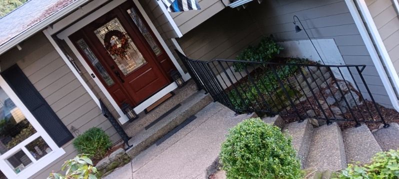 A house with a red door and stairs leading up to it.