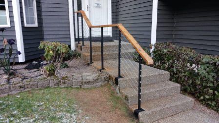 A house with stairs and a railing on the side of it.