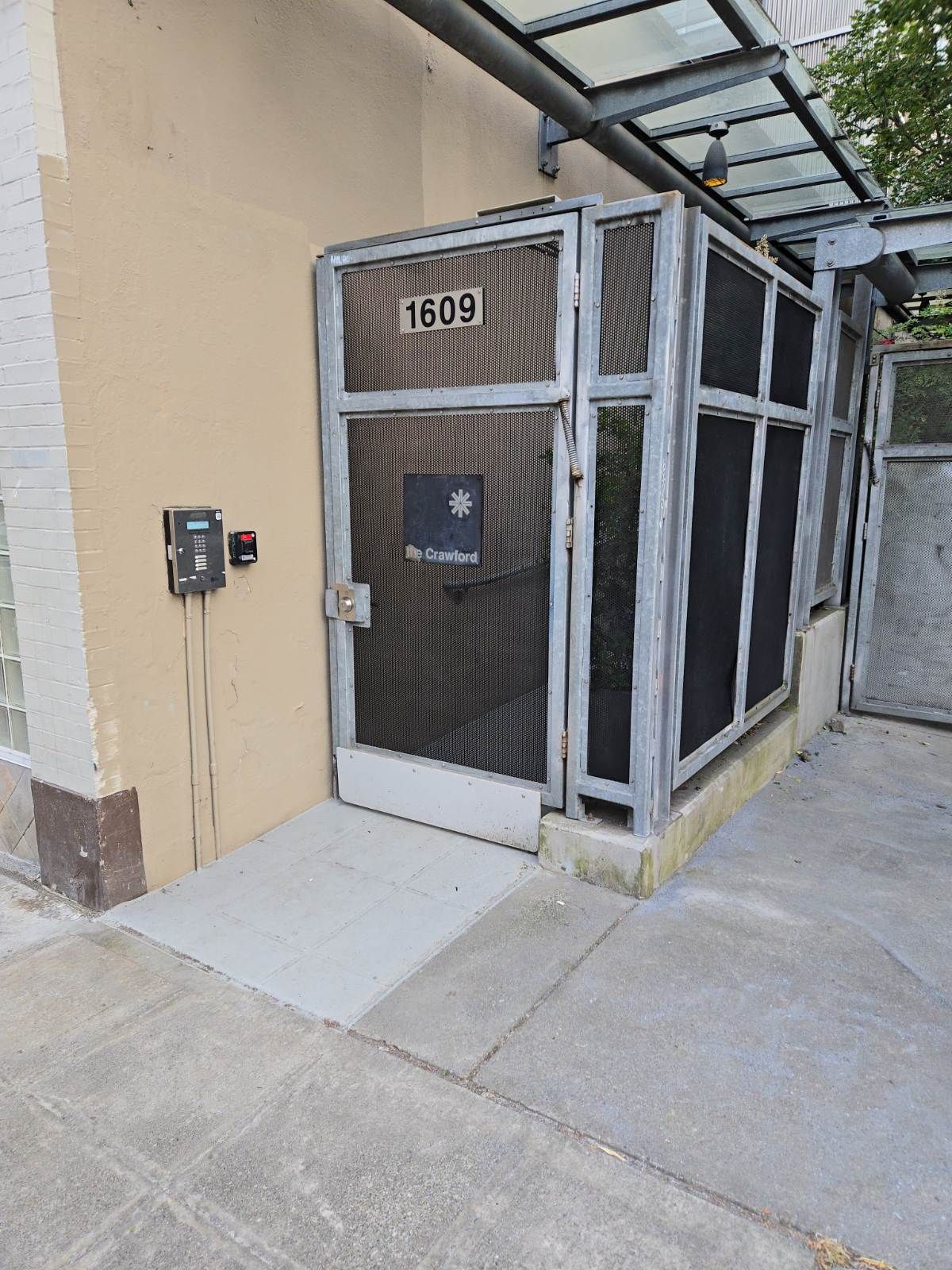 A screened in entrance to a building with a handicap ramp.