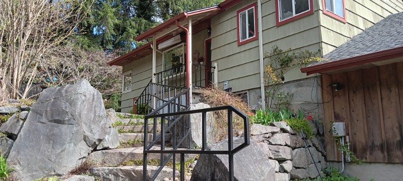 A house with stairs leading up to the front door and a railing.