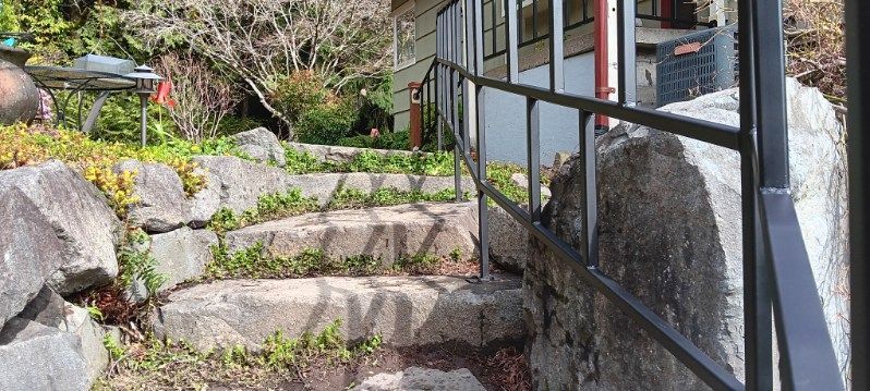A set of stairs leading up to a building with a metal railing.