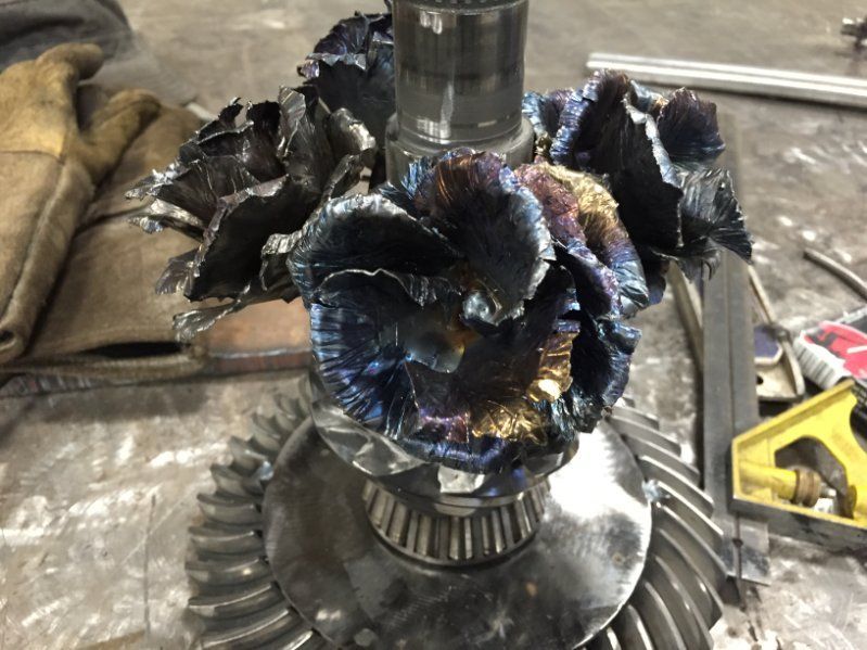 A metal flower is sitting on top of a gear