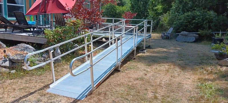 A wheelchair ramp is in the backyard of a house.